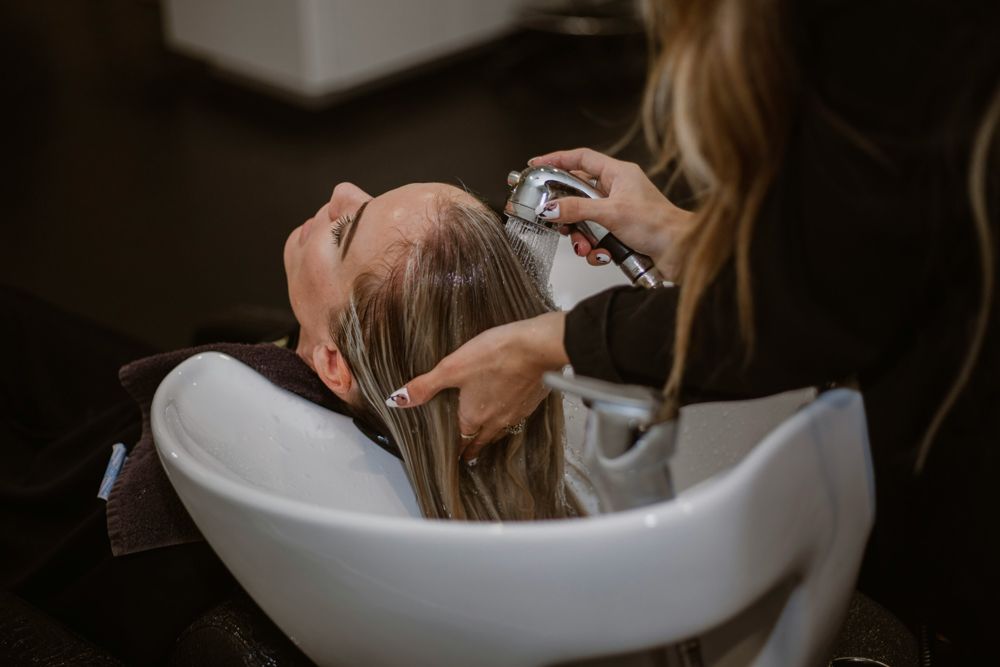 Peluquera lavando el pelo a una clienta